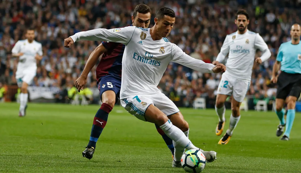 Pemain Real Madrid, Cristiano Ronaldo berebut bola dengan pemain Eibar, Gonzalo Escalante dalam lanjutan La Liga pekan kesembilan di Stadion Santiago Bernabeu, Minggu (22/10). Madrid menang tiga gol tanpa balas. (AP/Francisco Seco)