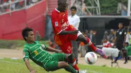 Pemain Semen Padang FC Joshua Pahabol (kanan) dihadang pemain Persebaya 1927 Taufiq saat menggiring bola pada pertandingan lanjutan Liga Prima Indonesia Sportindo di Staion H.Agus Salim Padang, Sumbar, Sabtu (14/4). Dalam pertandingan tersebut Semen Padang FC menang tipis dari lawannya dengan skor akhir 2-1. (Antara)