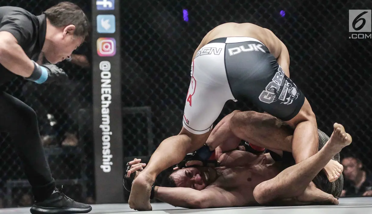 Dua petarung Indonesia Yohan Mulia Legowo (bawah) berusaha lepas dari teknik kunci Victorio Senduk (atas) pada laga One Championship di Jakarta, Sabtu (20/1). Pada laga tersebut Victorio Senduk menang atas Yohan Mulia. (Liputan6.com/Faizal Fanani)
