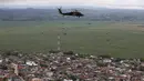 Helikopter anti-narkotika melayang di atas Apartado, Kolombia, Rabu (31/5). Petugas menyebarkan selebaran yang berisi informasi tentang kejahatan the Gulf Clan dan meminta warga untuk memberitahukan keberadaan laboratorium koka mereka. (AP /Fernando V)