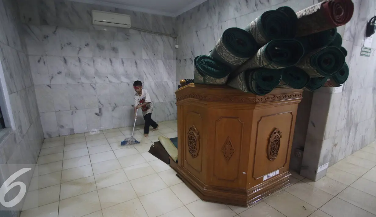 Seorang anak mengeluarkan air saat banjir menggenangi Mesjid An Nur di kawasan Pasar Minggu, Jakarta, Selasa (4/10). Banjir yang rutin menggenangi kawasan tersebut menyebabkan aktivitas warga serta ibadah terganggu. (Liputan6.com/Immanuel Antonius)