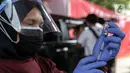 Petugas menyiapkan vaksin COVID-19 saat pelaksanaan vaksinasi drive-thru di Mapolres Jakarta Selatan, Selasa (29/6/2021). Polres Metro Jakarta Selatan membuka gerai vaksin presisi dengan menyediakan layanan vaksin COVID-19 gratis kepada warga ber-KTP Jakarta Selatan. (Liputan6.com/Faizal Fanani)