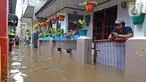 Warga bermain ponsel saat banjir merendam RW 06 kawasan Mekarsari, Depok, Jawa Barat, Sabtu (20/2/2021). Banjir yang disebabkan meluapnya aliran Kali Cipinang Timur ini terjadi akibat intensitas hujan tinggi di wilayah tersebut (Liputan6.com/Herman Zakharia)