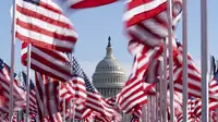 Capitol AS terlihat di antara bendera-bendera yang ditempatkan di National Mall menjelang pelantikan Presiden terpilih Joe Biden di Washington, Senin (18/1/2021). Acara pengambilan sumpah Joe Biden  akan berada dalam situasi berbeda dari pelantikan-pelantikan sebelumnya. (AP Photo/Alex Brandon)