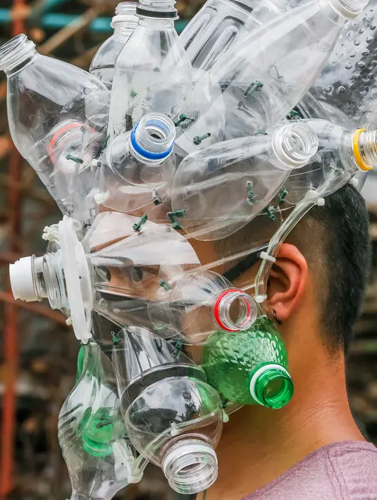 Seniman Filipina Leeroy New mengenakan masker improvisasi di studionya di Manila, 22 Mei 2020. Leeroy New menggunakan botol plastik daur ulang, gelas dan kok untuk membuat masker artistik COVID-19 yang juga akan tampilkan dalam pameran online bersama seniman visual lainnya. (Xinhua/Rouelle Umali)