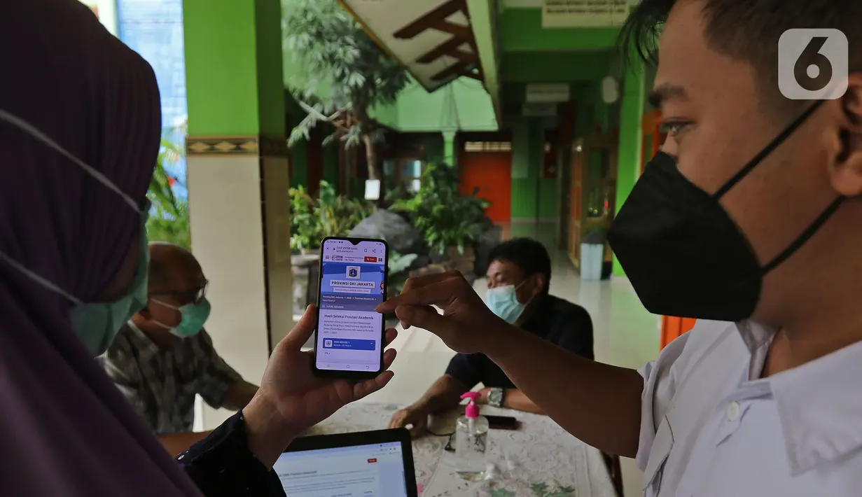 Guru menjelaskan informasi pengajuan akun untuk mengikuti proses  PPDB 2021/2022 di SMA Negeri 87 Jakarta, Senin (7/6/2021).  Pada tahun ini, ada empat jalur pendaftaran yang dibuka meliputi jalur prestasi, afirmasi, zonasi, perpindahan tugas orang tua dan anak guru. (Liputan6.com/Herman Zakharia)