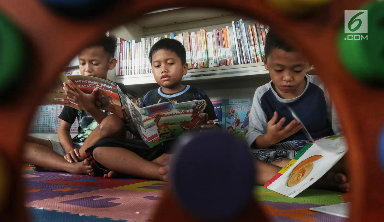 Anak-anak membaca buku di Ruang Perpustakaan RPTRA Kebon Sirih, Jakarta, Kamis (4/4). Gerakan Baca Jakarta dibuat untuk menumbuhkan generasi cerdas yang gemar membaca serta sadar literasi. (Liputan6.com/JohanTallo)