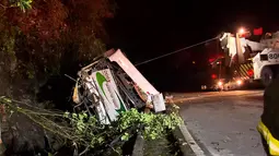 Alat derek menarik sebuah bus yang terjun bebas ke jurang di negara bagian Sao Paulo, Brasil, Kamis (9/6). Sopir dari bus yang membawa 46 penumpang kehilangan kendali dan menabrak sebuah batu di jalur berlawanan. (RECORD TV/AFP)