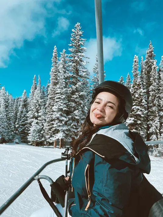 Enzy Storia tampil chic saat main kereta salju. Ia memilih mengenakan puffer jacket berwarna biru navy. [Foto: Instagram/enzystoria]