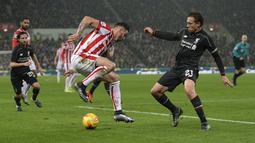 Pemain Stoke City, Geoff Cameron mengecoh pemain Liverpool, Lucas Leiva (kanan)  Pada Leg pertama semi-final Piala Liga Inggris di Stadion Britannia, Stoke-on-Trent, Inggris, Rabu (06/01/2016) dini hari WIB. (AFP Photo/Oli Scarff)