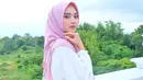 Penampilan Fida D'Academy saat liburan memang tampak begitu santai. Kali ini ketika menikmati pemandangan pepohonan hijau, ia terlihat mengenakan baju putih yang dipadukan dengan hijab ungu muda. (Liputan6.com/IG/@fida310)