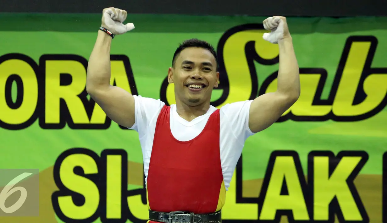Lifter Jawa Timur, Eko Yuli Irawan mengangkat tangan usai memastikan emas di kelas 62kg putra PON XIX Jabar di Gymnasium Stadion Si Jalak Harupat, Kab Bandung, Selasa (20/9/2016). Total angkatan Eko Yuli mencapai 307kg. (Liputan6.com/Helmi Fithriansyah)