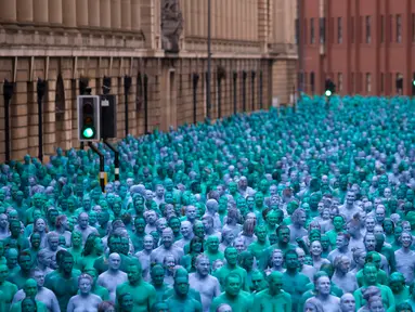 Ribuan orang dengan tubuh di cat berwarna biru bertelanjang bulat saat menjadi model sebuah seni berjudul "Sea of Hull" karya Spencer Tunick asal Amerika Serikat di pusat Kota Hull, Inggris, Sabtu (9/7). (AFP Photo/Jon Super)