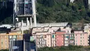 Sejumlah kendaraan berada di atas jembatan Morandi, dekat dengan bagian jalan layang yang runtuh, di kota Genoa, italia, Selasa (14/8). Jembatan yang dibangun pada 1960-an itu ambruk saat hujan deras dan angin kencang. (AP/Antonio Calanni)