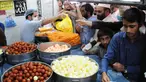 Orang-orang membeli penganan manis tradisional di hari raya Idul Fitri di Peshawar, Pakistan barat laut, pada 25 Mei 2020. Warga Pakistan memiliki tradisi memakan penganan manis saat merayakan Idul Fitri, yang menandai akhir bulan puasa Ramadan. (Xinhua/Saeed Ahmad)