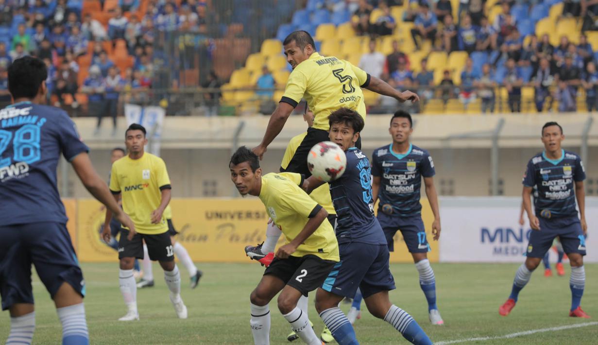 Striker Persib Bandung, Yandi Sofyan duel udara dengan pemain Malaysia All Stars pada laga persahabatan di Stadion Si Jalak Harupat, Bandung, Sabtu (24/10/2015). (Bola.com/Nicklas Hanoatubun)