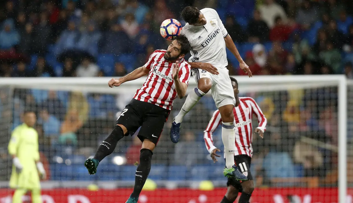 Pemain Real Madrid, Raphael Varane berduel dengan pemain Athletic Bilbao, Raul Garcia pada lanjutan La Liga di Santiago Bernabeu stadium, Madrid, senin (23/10/16) dini hari WIB. (AP/Daniel Ochoa de Olza)