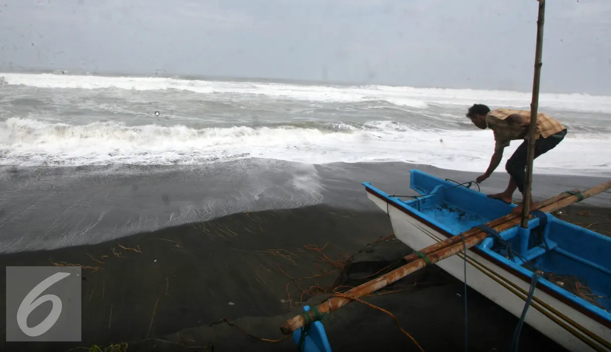 Nelayan memasangkan tali ke parahunya agar tidak terbawa gelombang pasang di Pantai Depok, Yogyakarta,Kamis (9/6). BMKG Yogyakarta mengatakan bahwa tinggi gelombang di perairan laut selatan mencapai 2,5 hingga 4 meter,  (Liputan6.com/Boy Harjanto)