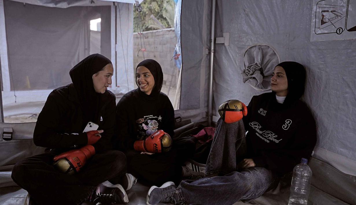 Gadis-gadis Palestina beristirahat setelah berlatih di klub tinju wanita yang didirikan di dalam tenda di Kota Gaza, Selasa 5 Mei 2026. (AP Photo/Jehad Alshrafi)