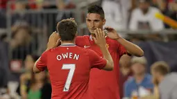 Striker Manchester United, Michael Owen (belakang) merayakan gol yang dicetak Federico Macheda ke gawang New England Revolution pada laga pramusim 2011/2012 di Gillette Stadium, Foxboro (13/7/2011). Michael Owen langsung mengenakan nomor punggung 7 saat pertama kali didatangkan MU dari Liverpool hingga meninggalkan MU pada akhir musim 2011/2012. Ia mewarisi nomor keramat tersebut secara berurutan dari Andrey Kanchelskis, David Beckham hingga Cristiano Ronaldo. (AFP via Getty Images/Jim Rogash)