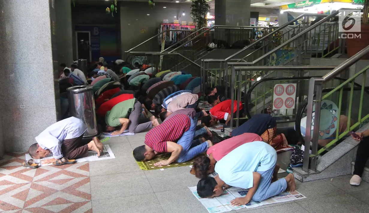 Sejumlah umat muslim melaksanakan salat jumat pada bulan Ramadan di selasar Pasar Tanah Abang, Jakarta, Jumat (25/5). Aktivitas jual beli di sekitaran lokasi salat Jumat berhenti saat salat, akses ditutup dan tak bisa dilalui. (Liputan6.com/Arya Manggala)