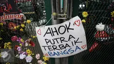 Poster bertuliskan dukungan untuk Basuki Tjahaja Purnama (Ahok) terpasang di pagar halaman Rutan Cipinang, Jakarta, Rabu (10/5). Poster dan karangan bunga terus berdatangan, meski Ahok sudah dipindahkan ke Rutan Mako Brimob. (Liputan6.com/Faizal Fanani)