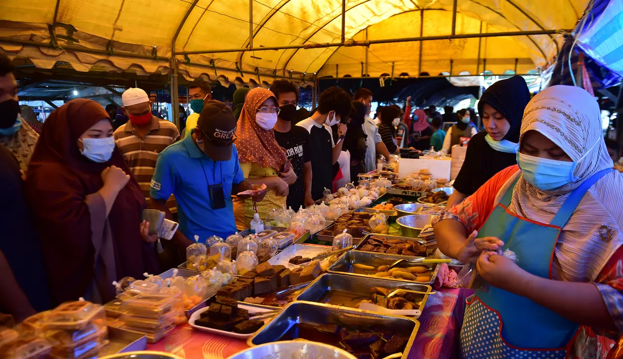 Orang-orang berbelanja di pasar makanan pada hari pertama bulan suci Ramadhan di provinsi Narathiwat di Thailand selatan (24/4/2020). Sejumlah pedagang menjual berbagai makanan selama bulan suci Ramadan di pasar tersebut. (AFP/Madaree Tohlala)