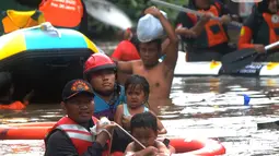 Petugas Pemadam Kebakaran mengevakuasi anak-anak korban banjir dengan menggunakan ban di kawasan Karet Pasar Baru Barat, Jakarta, Selasa (25/2/2020). Banjir yang terjadi sejak subuh akibat luapan Kanal Banjir Barat tersebut merendam ratusan rumah hingga setinggi dua meter. (merdeka.com/Arie Basuki)