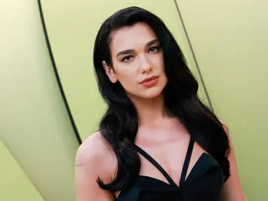 Dua Lipa berpose saat tiba untuk peragaan busana Versace Fall/Winter 2023 di Pacific Design Center, West Hollywood, California, Amerika Serikat, 9 Maret 2023. Penyanyi sekaligus penulis lagu asal Inggris ini tampil memukau dengan tampilan Hollywood kuno. (Michael Tran/AFP)