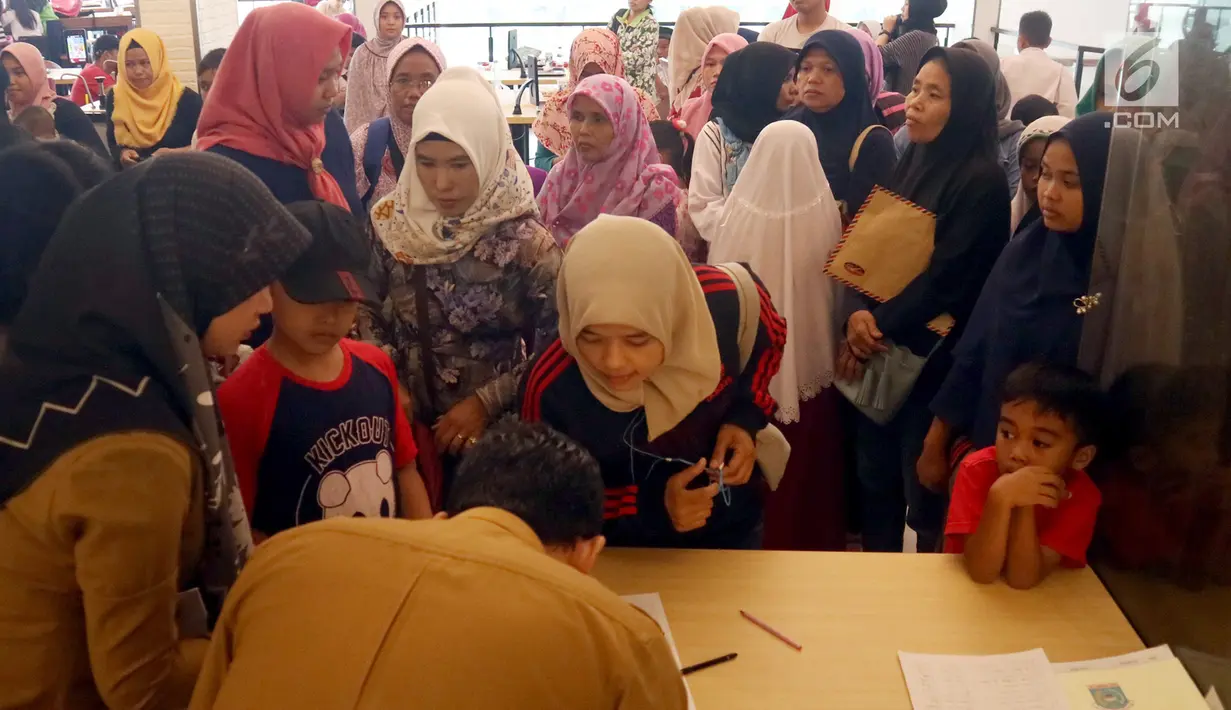 Petugas Disdukcapil Kota Tangerang Selatan melayani pembuatan Kartu Identitas Anak (KIA) di tempat makan siap saji kawasan Bintaro Tangerang Selatan, Selasa (26/2). (Merdeka.com/Arie Basuki)