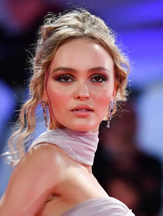 Aktris Lily-Rose Depp berpose setibanya di pemutaran perdana film 'The King' di Festival Film Venice edisi ke-76, Venice, Italia (2/9/2019). Putri aktor Johnny Depp ini tampil memesona berbalut gaun berwarna pink di karpet merah Venice Film Festival 2019. (AFP Photo/Alberto Pizzoli)