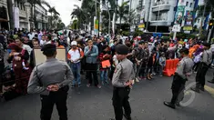 Petugas kepolisian menjaga ketat jalan yang dilalui Para kepala Negara dan delegasi dari Asia dan Afrika mengikuti 'Historical Walk' dalam rangkaian Peringatan KAA ke-60, di Jalan Asia Afrika, Bandung, Jumat (24/4/2015). (Liputan6.com/Faizal Fanani)