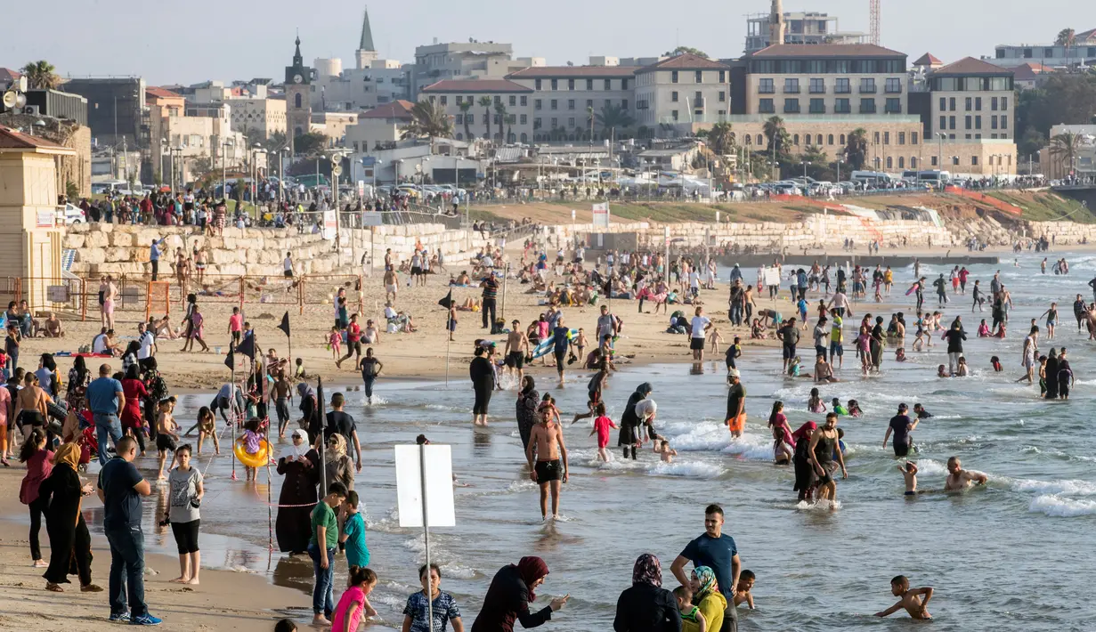 Suasana di pantai laut Mediterania saat sejumlah muslim berwisata sambil menghabiskan libur lebaran di Tel Aviv, Israel, 26 Jni 2017. (AFP PHOTO / JACK GUEZ)