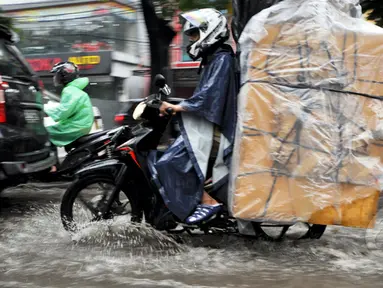 Sejumlah kendaraan melintasi genangan air di Jalan Iskandar, Jakarta, Kamis (22/1/2015). (Liputan6.com/Miftahul Hayat)