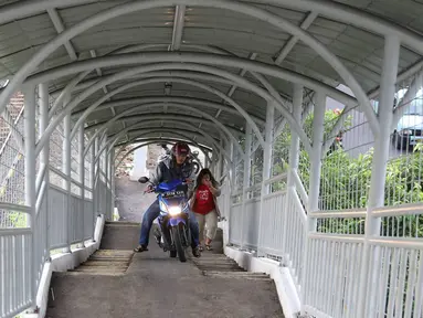 Pemotor melintasi JPO untuk menyeberangi rel kereta di kawasan Pasar Minggu, Jakarta, Selasa (6/9). Selain melanggar aturan, perilaku buruk pemotor tersebut juga membahayakan keselamatan diri sendiri serta pejalan kaki. (Liputan6.com/Immanuel Antonius)