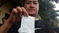 Riski Riswandi, pemilik warung nasi bebek menunjukkan nota transaksi pembelian palsu yang diambil paksa dari tangan pengemudi transportasi online di Kota Malang (Liputan6.com/Zainul Arifin)
