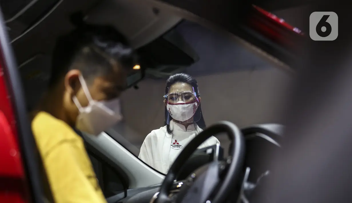 SPG berdiri dekat mobil yang dipamerkan di Indonesia International Motor Show (IIMS) Hybrid 2021, JiExpo Kemayoran, Jakarta, Kamis (16/4/2021). Acara digelar secara daring dan kunjungan langsung dengan pembatasan kapasitas dan penerapan protokol kesehatan COVID-19. (Liputan6.com/JohanTallo)