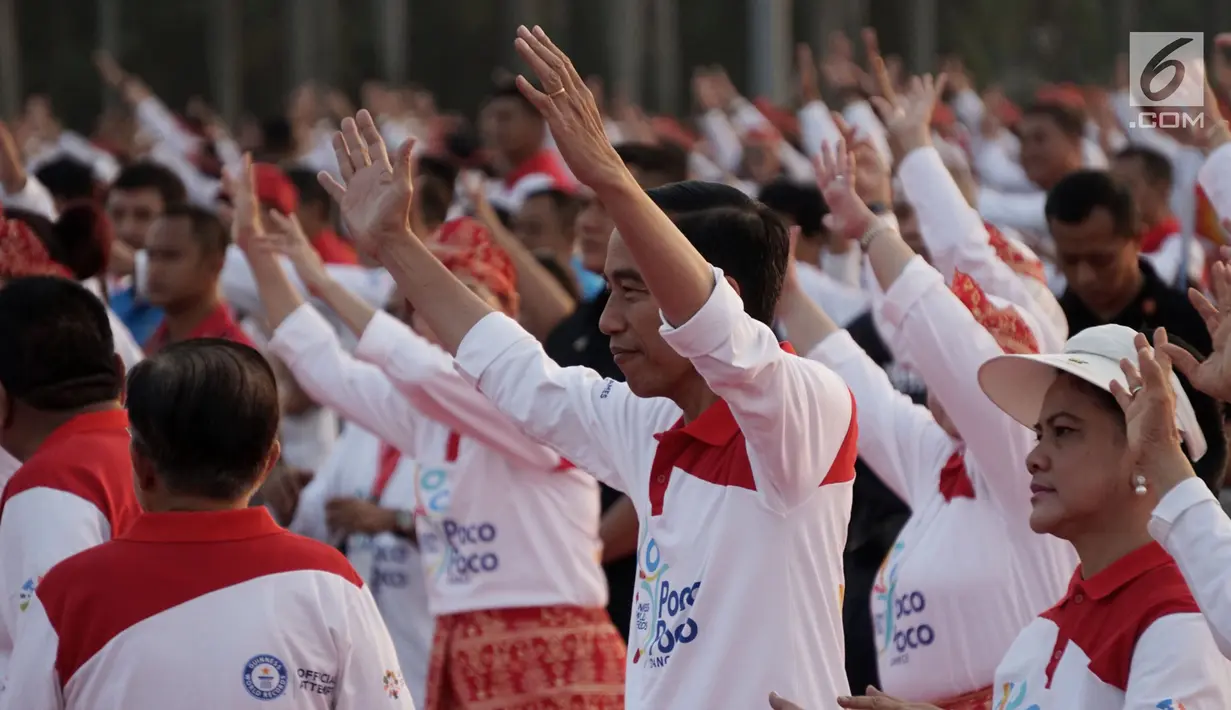 Presiden Joko Widodo bersama Ibu Negara Iriana menari Poco-Poco dalam rangka pemecahan rekor Guinness World Records di Lapangan Monas, Jakarta, Minggu (5/8). Acara ini dihadiri sejumlah pejabat tinggi negara. (Merdeka.com/Iqbal S. Nugroho)