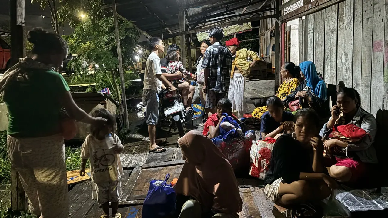 Korban banjir di Kota Pekanbaru menunggu tim evakuasi datang karena luapan Sungai Siak makin tinggi.