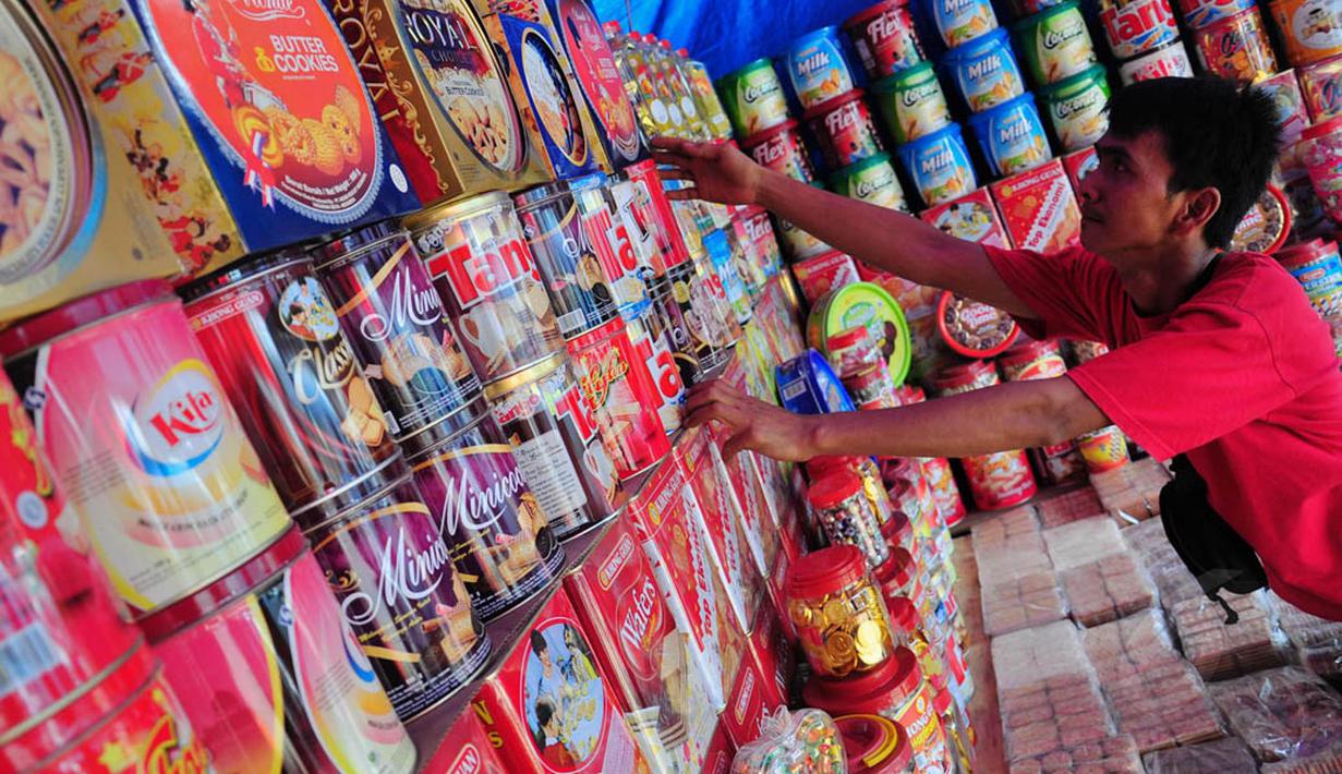 Seorang pedagang merapikan kue kering Lebaran di Jl Raya Bogor Km 26, Jakarta, Minggu (20/7/14). (Liputan6.com/Faizal Fanani)