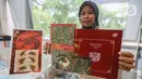 Salah satu karyawan PT Pos Indonesia menunjukkan prangko seri Imlek 2024 Tahun Naga Kayu 2575 di Kantor Pos Indonesia, Jakarta, Rabu (7/2/2024). (Liputan6.com/Angga Yuniar)