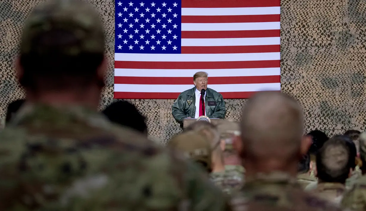 Presiden Donald Trump berbicara di hadapan pasukan militer Amerika dalam kunjungan kejutan di Pangkalan Udara al Asad, Irak, Rabu (26/12). Trump memberikan kejutan dengan melakukan kunjungan mendadak tersebut dalam rangka perayaan Natal (AP/Andrew Harnik)