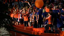 Tim sepak bola wanita Belanda menyapa para pendukung dari atas perahu saat merayakan kemenangannya di Utrecht, Belanda (7/9). Timnas dan tuan rumah Belanda berhasil mengalahkan Denmark 4-2. (AFP Photo/John Thys)