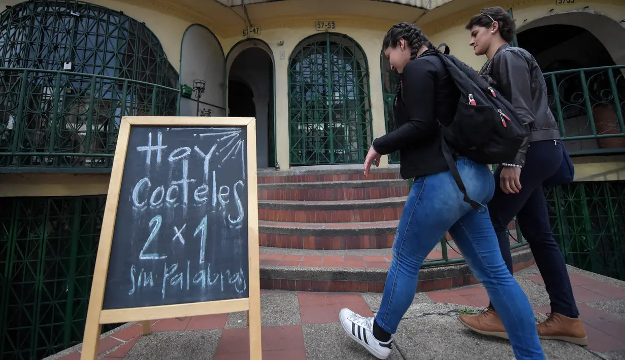 Pelanggan tunarungu masuk ke bar kopi "Sin Palabras" di Bogota (19/7).  Menu di kafe ini sangatlah unik dengan yang menggambarkan bahasa isyarat, lampu untuk memanggil pelayan dan lantai yang bergetar sesuai irama musik. (AFP Photo/Raul Arboleda)