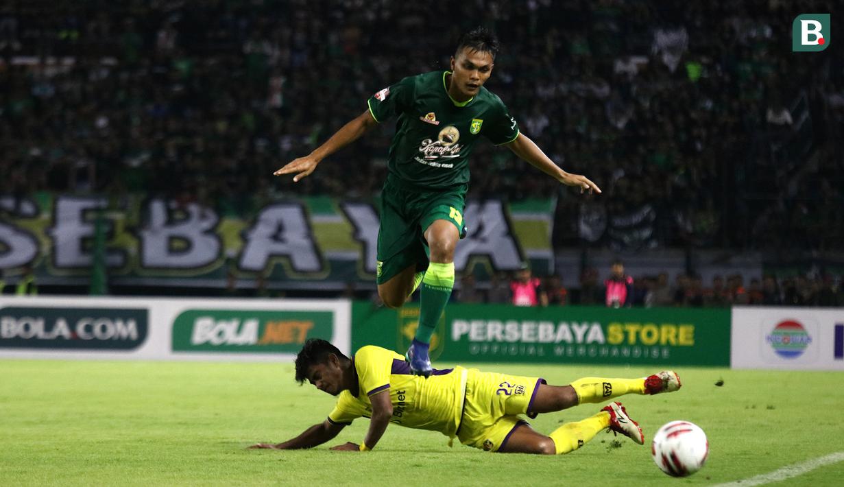 Bek Persebaya, Rachmat Irianto, berusaha melewati pemain Persik Kediri, Ibrahim Sanjaya, pada laga pembuka Shopee Liga 1 2020, Sabtu (29/2). Persebaya dan Persik bermain imbang 1-1. (Bola.com/Aditya Wany)