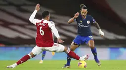 Pemain Arsenal, Gabriel, berusaha menghadang penyerang Southampton, Theo Walcott, pada laga Liga Inggris di Stadion Emirates, Kamis (17/12/2020). Kedua tim bermain imbang 1-1. (Peter Cziborra/Pool via AP)