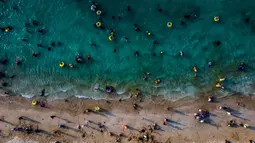 Terletak di Aceh Besar, Pantai Lhoknga, merupakan salah satu destinasi wisata paling menakjubkan di Indonesia. Tampak foto udara menunjukkan orang-orang saat berkumpul menikmati masa libur panjang Idulfitri di area olahraga air, Pantai Lhoknga, Aceh, pada Kamis 26 Maret 2026. (Chaideer MAHYUDDIN/AFP)