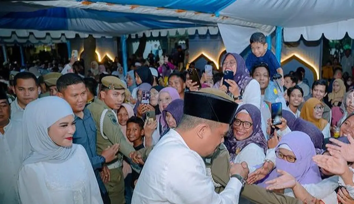 Aaliyah Massaid mengenakan dress putih panjang dengan lace di bagian bawah dress dipadukan kerudung model pashmina warna serasi. [@aaliyah.massaid]