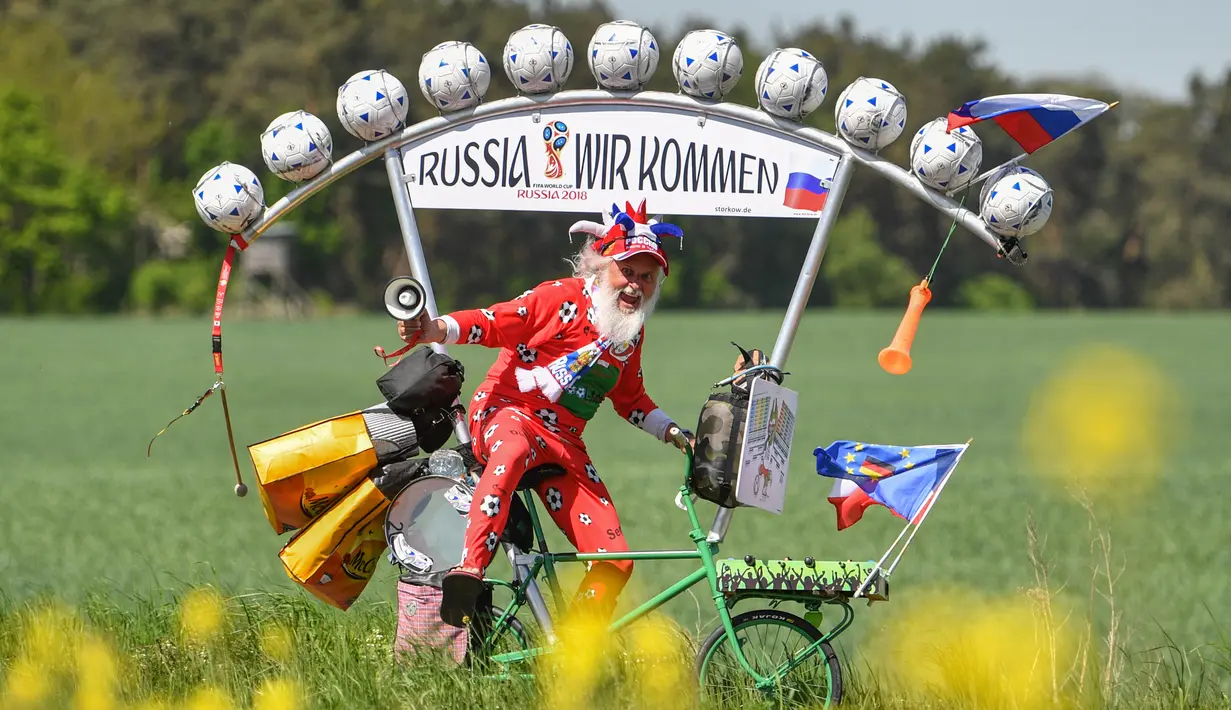Perancang sepeda asal Jerman, Dieter Senft atau Didi the Devil saat mengendarai sepeda unik buatannya di Briesen, Jerman Timur, Senin (7/5). Aksi itu dia lakukan untuk mempromosikan Piala Dunia 2018. (Patrick Pleu/dpa/AFP)