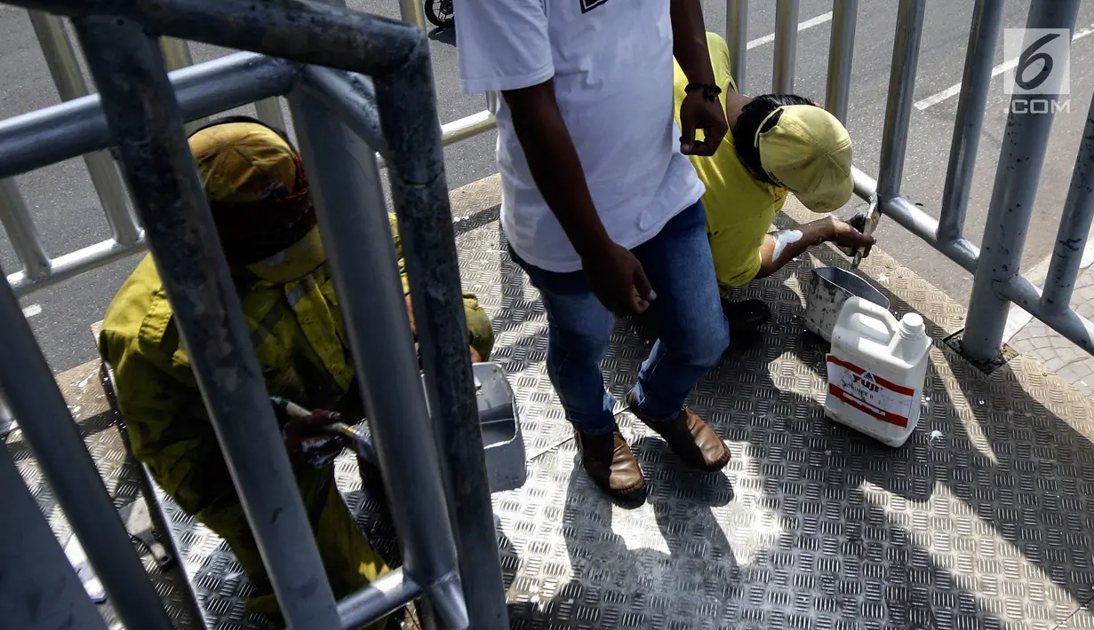 Petugas Dinas Bina Marga DKI Jakarta mengecat jembatan penyeberangan orang (JPO) di Jalan Daan Mogot, Jakarta Barat, Rabu (7/8/2019). Selain merawat fasilitas umum, pengecatan ini juga untuk mempercantik dan mencegah bagian JPO dari kerapuhan. (Liputan6.com/JohanTallo)